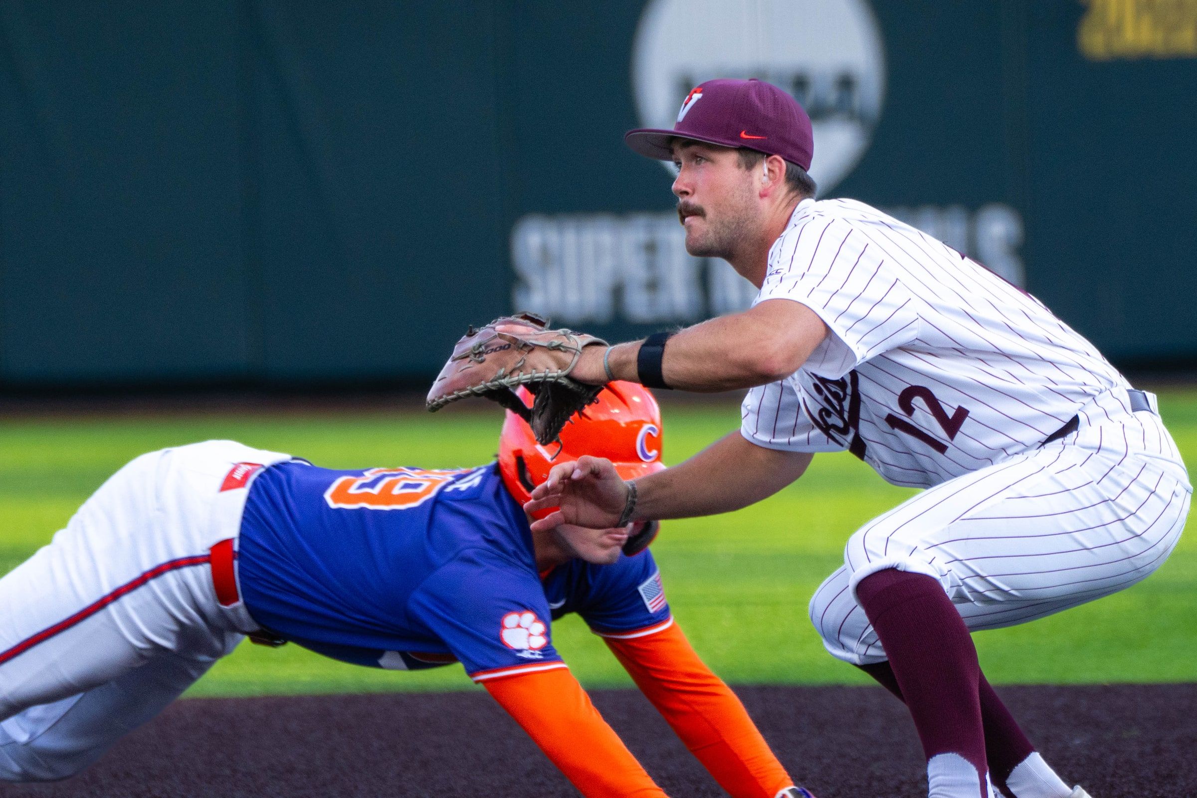 Baseball runner diving back to first base as the first baseman takes the throw